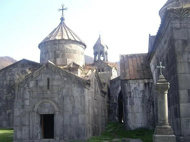 Stone buildings of Sanahin Monastery with conical roofs and cross on top