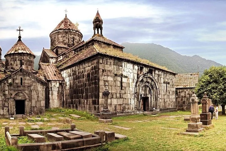 Extérieur du monastère de Sanahin avec des tombes en pierre au premier plan