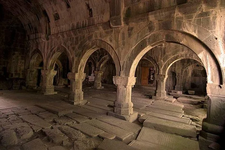 Vue intérieure du monastère de Sanahin avec arches en pierre et dalles de sol gravées
