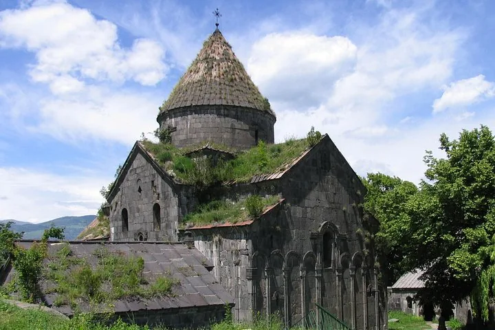 Exterior view of Sanahin Monastery showing stone walls and a conical roof