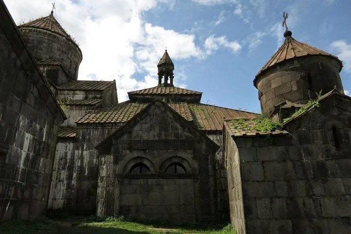 Low angle view of Sanahin Monastery featuring tiled roofs and stone architecture