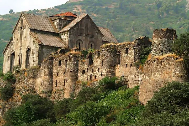 Eine alte Steinanlage, möglicherweise das Kloster Sanahin, auf einem felsigen Hügel.